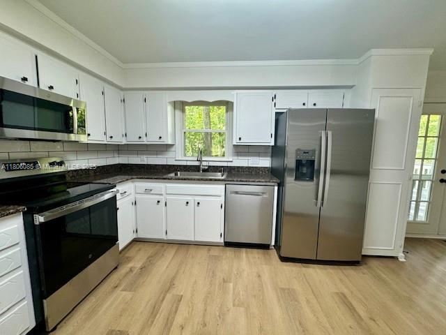 902 Vickie Dr, ,, NC 27511 - kitchen with appliances with stainless steel finishes, a sink, dark countertops, and crown molding