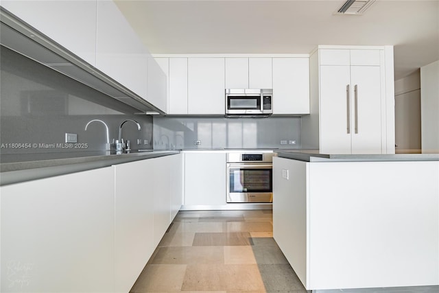 88 SW 7th St Unit 2504, Miami, FL 33130 - kitchen featuring appliances with stainless steel finishes, modern cabinets, white cabinets, and a sink