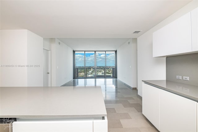 88 SW 7th St Unit 2504, Miami, FL 33130 - kitchen with expansive windows, white cabinetry, modern cabinets, light flooring, and baseboards