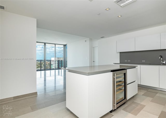 88 SW 7th St Unit 2504, Miami, FL 33130 - kitchen with beverage cooler, modern cabinets, white cabinetry, a kitchen island, and a sink