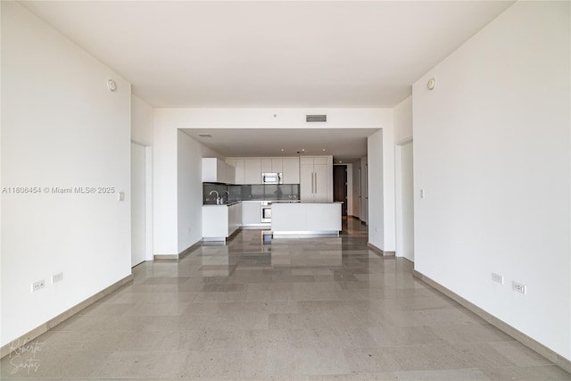 88 SW 7th St Unit 2504, Miami, FL 33130 - unfurnished living room with baseboards and a sink