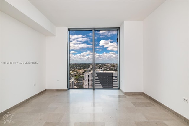 88 SW 7th St Unit 2504, Miami, FL 33130 - unfurnished room featuring a wall of windows and baseboards