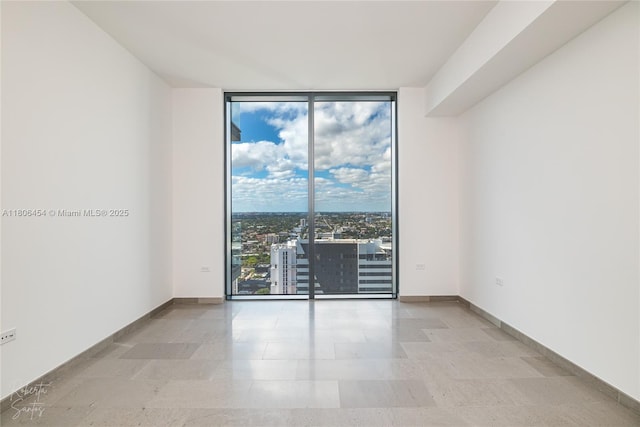 88 SW 7th St Unit 2504, Miami, FL 33130 - empty room featuring a wall of windows and baseboards