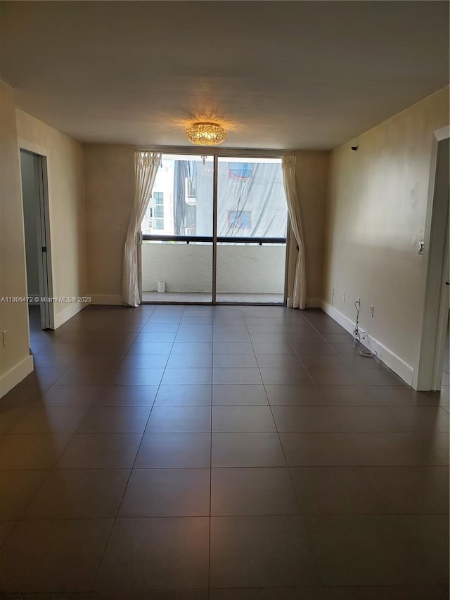 1775 Washington Ave Unit 4A, Miami Beach, FL 33139 - spare room featuring baseboards and dark tile patterned floors