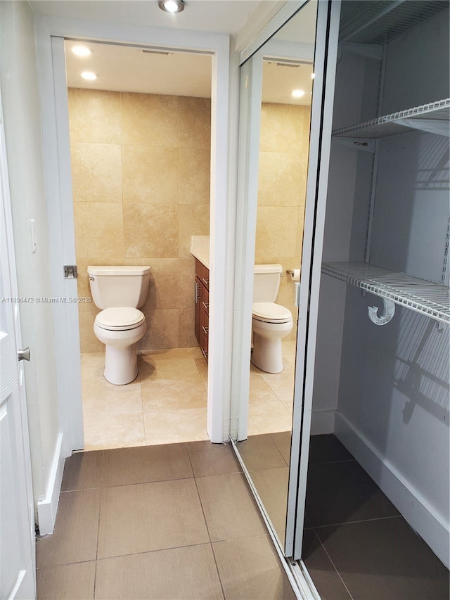 1775 Washington Ave Unit 4A, Miami Beach, FL 33139 - bathroom with toilet, tile patterned flooring, tile walls, vanity, and recessed lighting