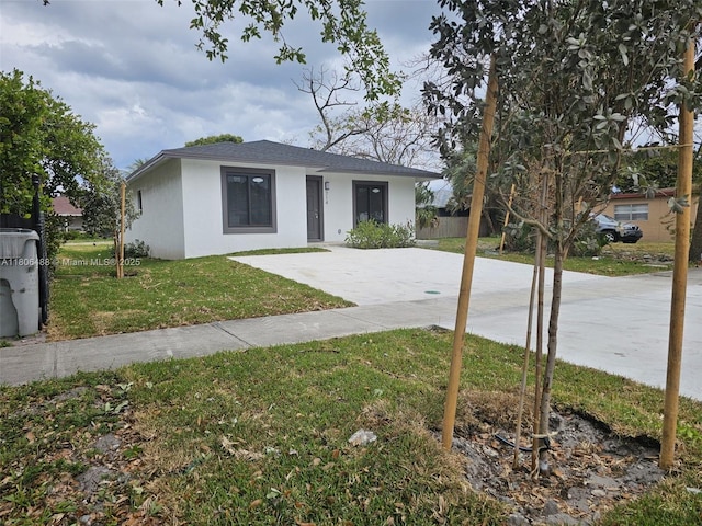 714 NW 4th Ave, Pompano Beach, FL 33060 - view of front facade with stucco siding, a front yard, and concrete driveway