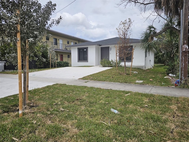 714 NW 4th Ave, Pompano Beach, FL 33060 - view of front facade with stucco siding, a front yard, and concrete driveway