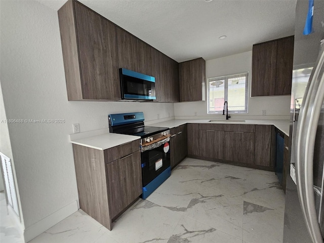 714 NW 4th Ave, Pompano Beach, FL 33060 - kitchen with appliances with stainless steel finishes, a sink, light marble finish floors, light countertops, and modern cabinets