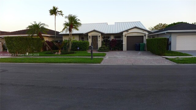 14430 SW 108th St, Miami, FL 33186 - ranch-style home featuring decorative driveway, stucco siding, an attached garage, and metal roof