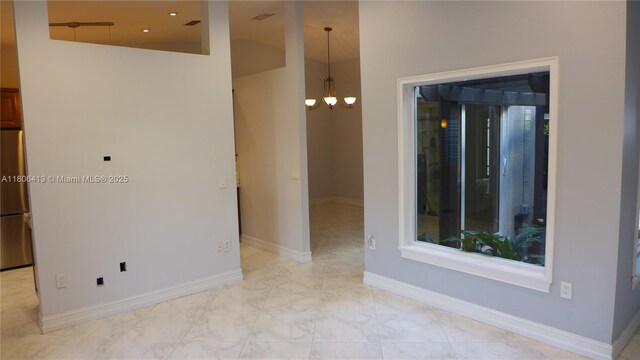 14430 SW 108th St, Miami, FL 33186 - unfurnished room featuring a chandelier, baseboards, and light marble finish flooring