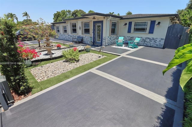 101 NE 9th Ave, Hialeah, FL 33010 - ranch-style home with stone siding, stucco siding, and a patio area
