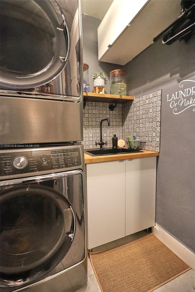 101 NE 9th Ave, Hialeah, FL 33010 - laundry room with stacked washer and clothes dryer, baseboards, and bar with sink