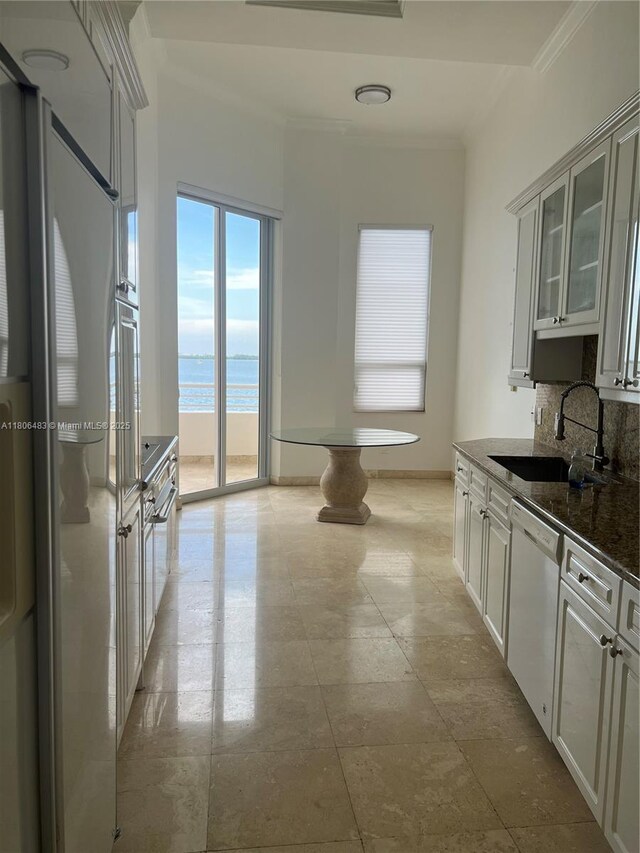 808 Brickell Key Dr Unit 404, Miami, FL 33131 - kitchen featuring a sink, white appliances, ornamental molding, tasteful backsplash, and glass insert cabinets