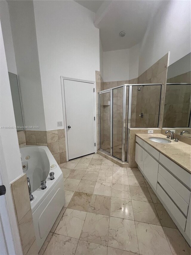 808 Brickell Key Dr Unit 404, Miami, FL 33131 - bathroom with a stall shower, vanity, marble finish flooring, a tub with jets, and tile walls