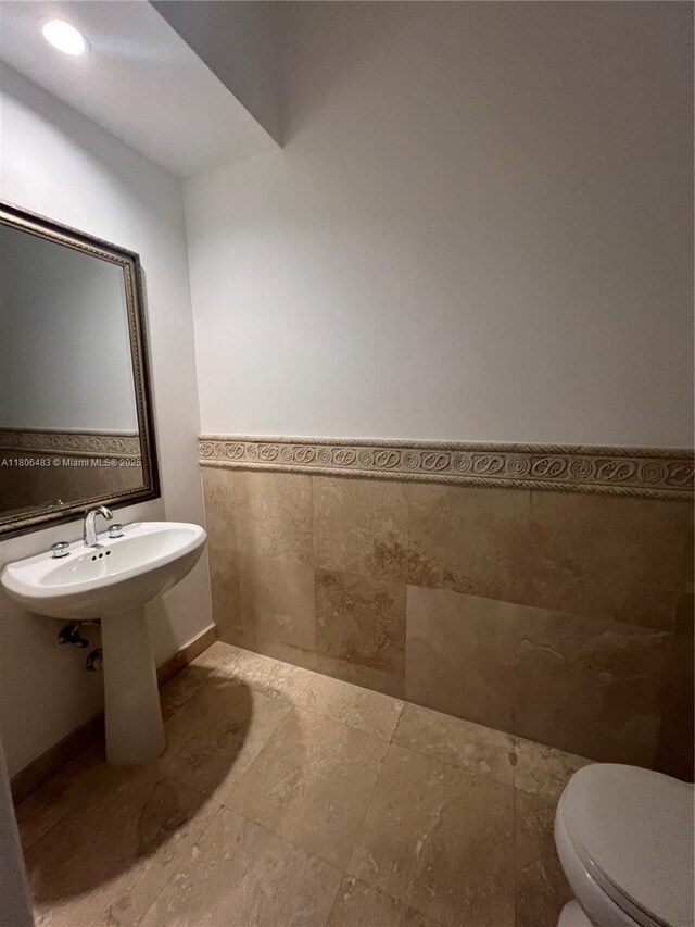 808 Brickell Key Dr Unit 404, Miami, FL 33131 - bathroom with tile walls, a wainscoted wall, and toilet
