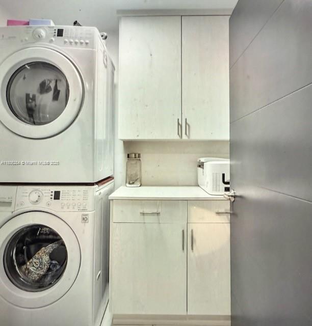 8992 Palm Tree Ln Unit 8992, Pembroke Pines, FL 33024 - laundry room with stacked washing machine and dryer and cabinet space