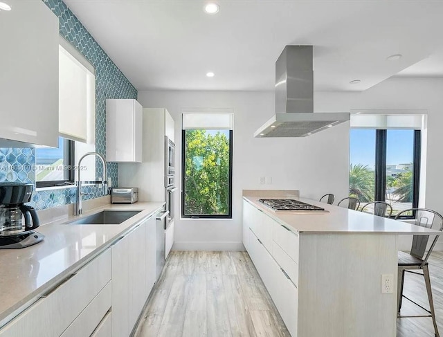 332 Balboa St, Hollywood, FL 33019 - kitchen with island exhaust hood, a sink, stainless steel appliances, modern cabinets, and a breakfast bar