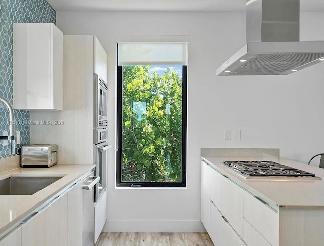 332 Balboa St, Hollywood, FL 33019 - kitchen with range hood, a sink, light countertops, and white cabinets