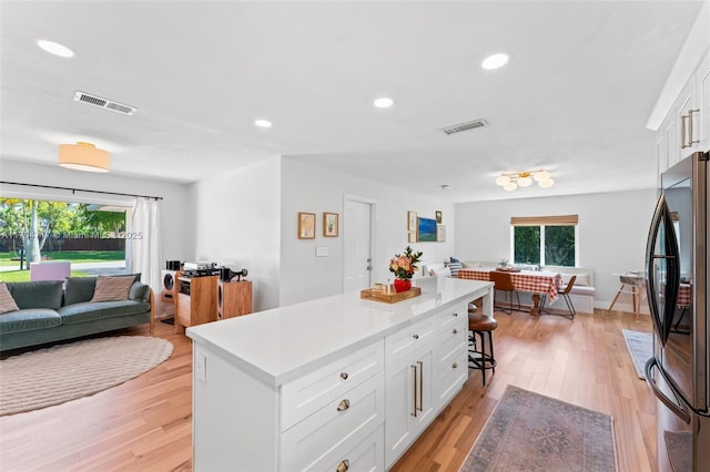 8885 SW 182nd Ter, Palmetto Bay, FL 33157 - kitchen featuring open floor plan, stainless steel fridge, white cabinets, light countertops, and recessed lighting