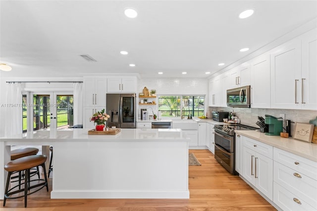 8885 SW 182nd Ter, Palmetto Bay, FL 33157 - kitchen featuring appliances with stainless steel finishes, tasteful backsplash, white cabinetry, and recessed lighting