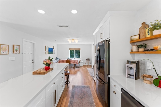 8885 SW 182nd Ter, Palmetto Bay, FL 33157 - kitchen with freestanding refrigerator, white cabinetry, light wood-style floors, light countertops, and recessed lighting