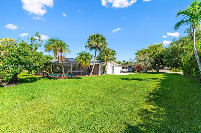 8885 SW 182nd Ter, Palmetto Bay, FL 33157 - view of green lawn with glass enclosure and a swimming pool
