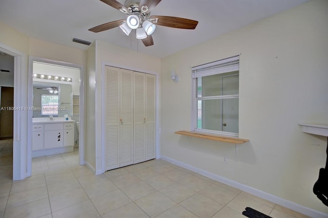 210 Joe Hilton St, Avon Park, FL 33825 - unfurnished bedroom featuring light tile patterned flooring, a closet, baseboards, a ceiling fan, and ensuite bathroom