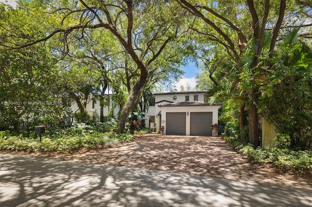 view of front of house with decorative driveway, stucco siding, and an attached garage