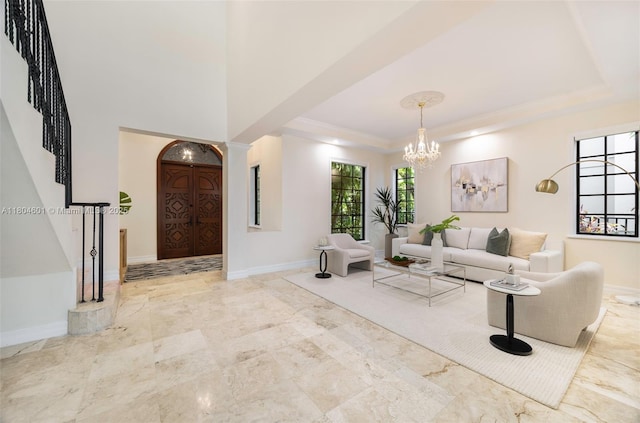 living room featuring a raised ceiling, a chandelier, stairs, baseboards, and crown molding