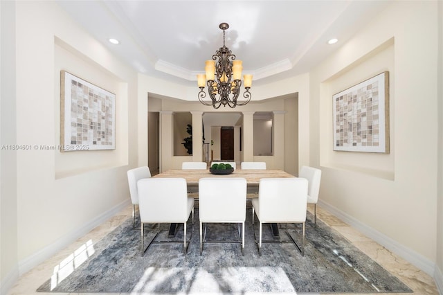 dining space with a chandelier, a tray ceiling, recessed lighting, decorative columns, and baseboards