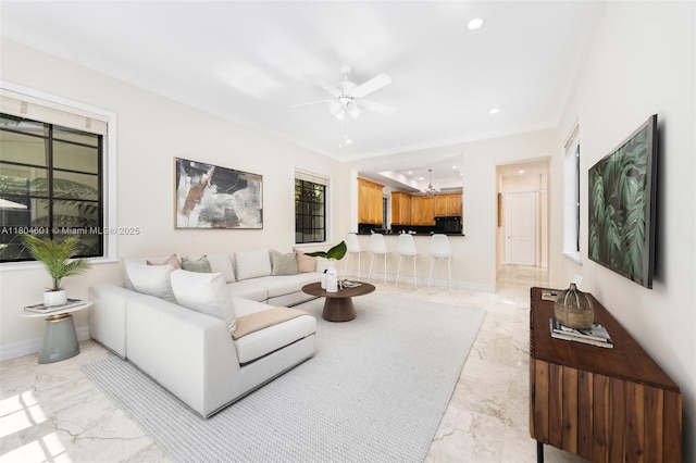 living area with light marble finish flooring, ornamental molding, a ceiling fan, recessed lighting, and a chandelier