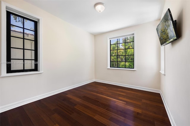 empty room with baseboards and wood finished floors