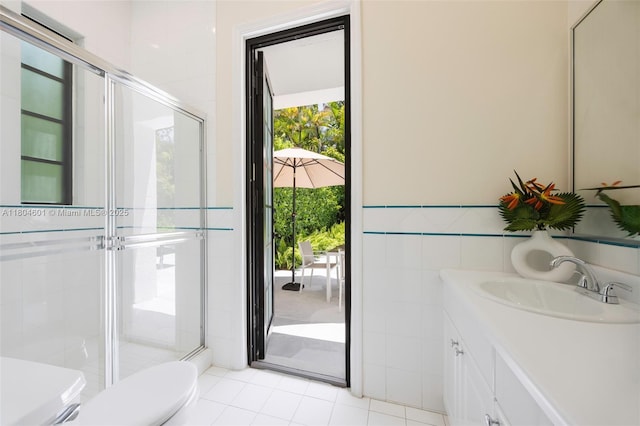 full bathroom featuring toilet, a shower stall, vanity, tile patterned floors, and tile walls