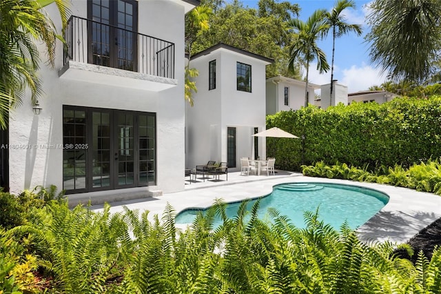 outdoor pool with a patio and french doors