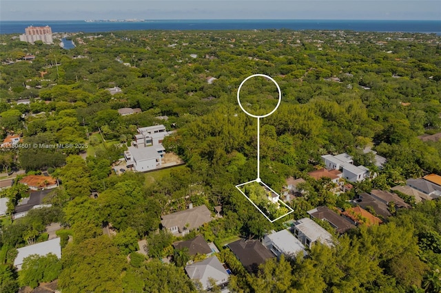 view of property location featuring property boundaries highlighted, a forest, and a nearby body of water