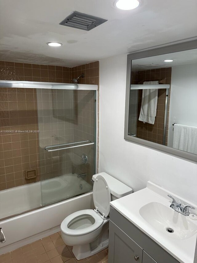1621 Collins Ave Unit 505, Miami Beach, FL 33139 - bathroom with tile patterned floors, recessed lighting, shower / bath combination with glass door, vanity, and toilet