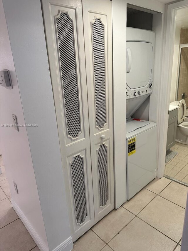 1621 Collins Ave Unit 505, Miami Beach, FL 33139 - laundry area featuring stacked washer and clothes dryer and light tile patterned floors