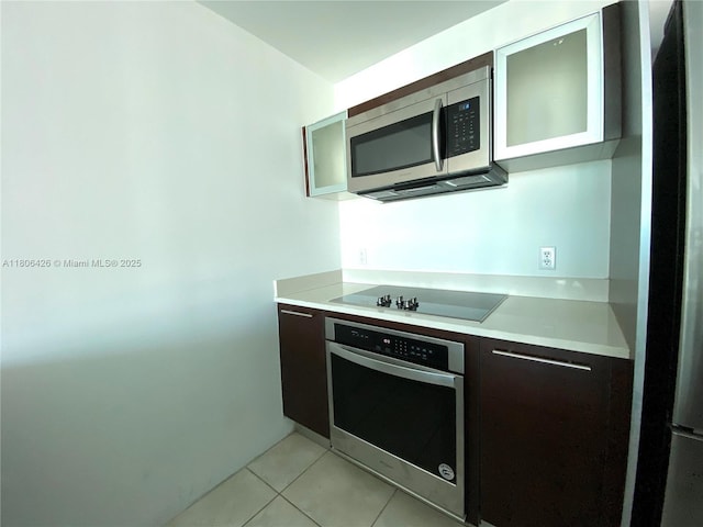 1900 N Bayshore Dr Unit 4708, Miami, FL 33132 - kitchen featuring stainless steel appliances, light countertops, light tile patterned flooring, glass insert cabinets, and modern cabinets