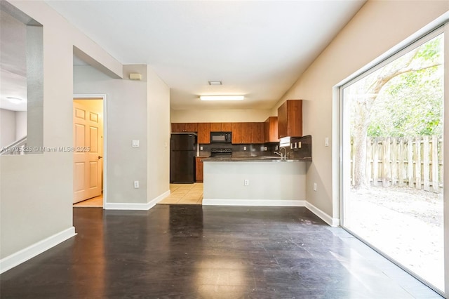 355 SE 20th Ter, Homestead, FL 33033 - kitchen featuring black appliances, brown cabinetry, a sink, a peninsula, and wood finished floors
