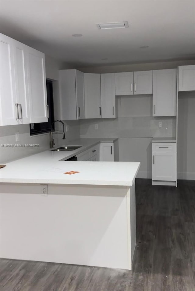 940 SW 78th Pl, Miami, FL 33144 - kitchen with a sink, a peninsula, dark wood finished floors, and white cabinets