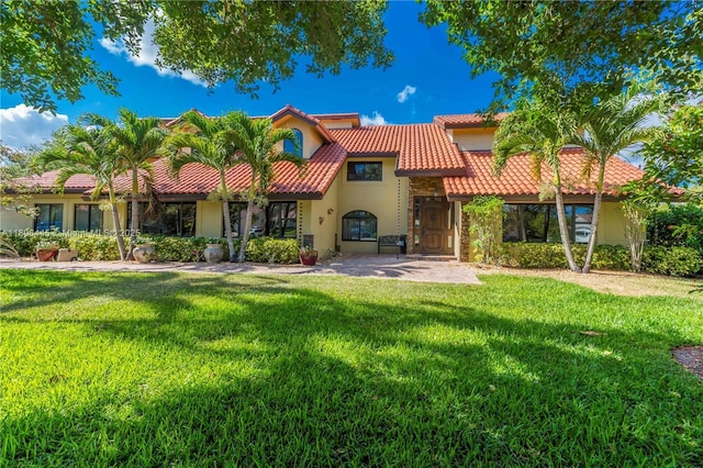 11915 Green Oak Dr, Davie, FL 33330 - rear view of house with a tile roof, stucco siding, and a yard