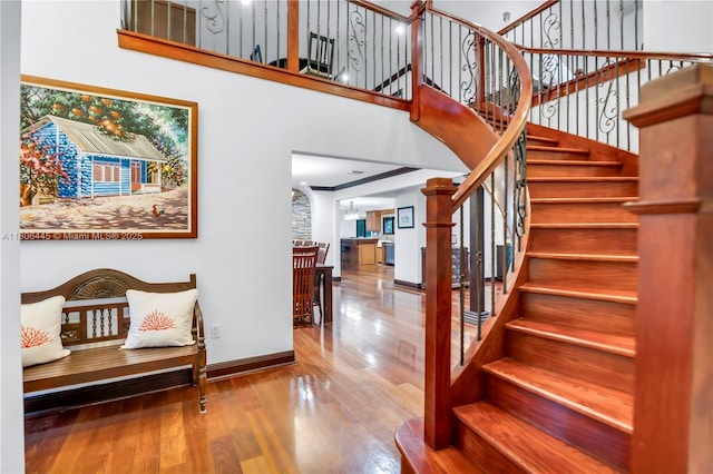 11915 Green Oak Dr, Davie, FL 33330 - staircase featuring wood finished floors, baseboards, arched walkways, and a high ceiling