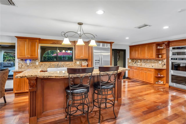 11915 Green Oak Dr, Davie, FL 33330 - kitchen featuring appliances with stainless steel finishes, open shelves, ornamental molding, a center island, and backsplash