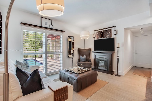 45 Antilla Ave Unit 1G, Coral Gables, FL 33134 - living area with light wood-type flooring, a glass covered fireplace, and baseboards