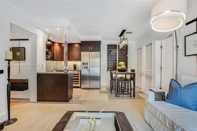 45 Antilla Ave Unit 1G, Coral Gables, FL 33134 - kitchen featuring appliances with stainless steel finishes, wine cooler, dark brown cabinets, light wood finished floors, and open floor plan