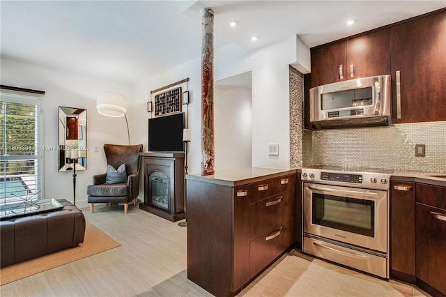 45 Antilla Ave Unit 1G, Coral Gables, FL 33134 - kitchen with appliances with stainless steel finishes, open floor plan, a warming drawer, dark brown cabinetry, and backsplash
