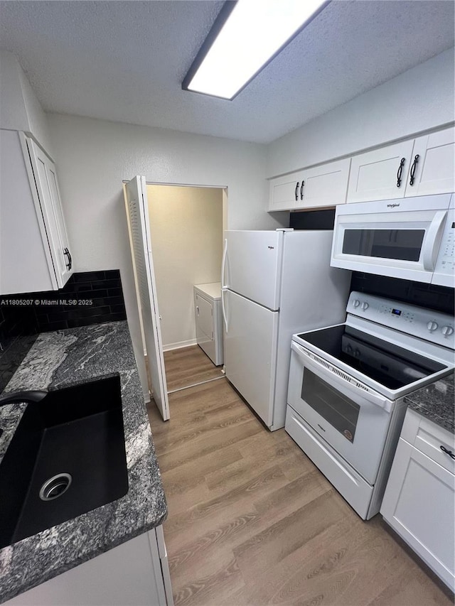 1055 S Hiawassee Rd Unit 2014, Orlando, FL 32835 - kitchen with white appliances, washing machine and dryer, white cabinetry, a sink, and light wood finished floors