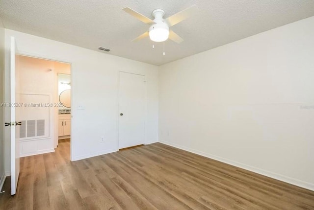 1055 S Hiawassee Rd Unit 2014, Orlando, FL 32835 - unfurnished bedroom featuring wood finished floors, baseboards, a textured ceiling, a closet, and a ceiling fan