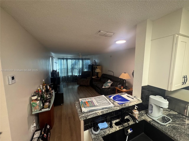 1055 S Hiawassee Rd Unit 2014, Orlando, FL 32835 - kitchen featuring a textured ceiling, wood finished floors, white cabinets, and a sink