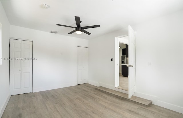 919 NW 13th St, Fort Lauderdale, FL 33311 - unfurnished bedroom featuring light wood-type flooring, baseboards, a ceiling fan, and two closets